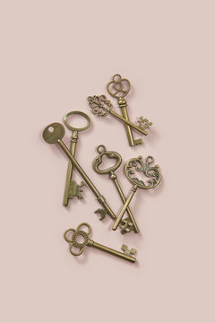 Antique ornate keys scattered on beige background