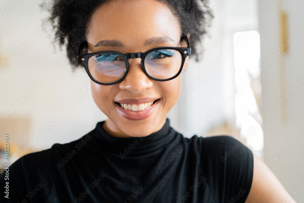 Wall mural portrait of a smiling woman with glasses - a freelancer working in an office