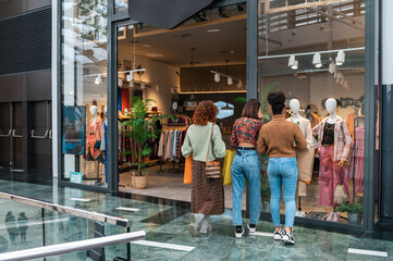 Diverse women looking into a shop window