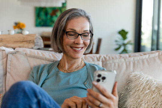 Beautiful Woman in Glasses Smiles at Her Phone