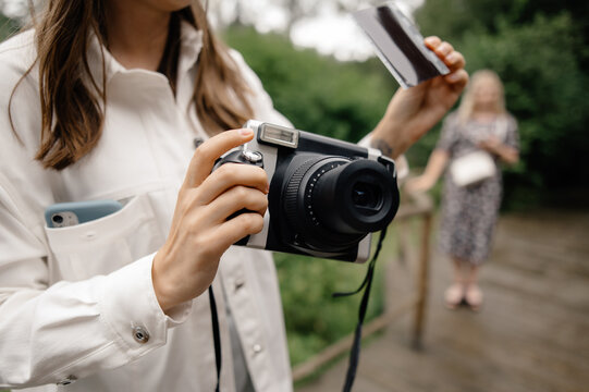 anonymous female take photo on polaroid instant camera