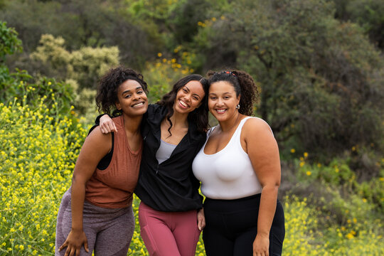 Three Women Smile While On A Walk In Nature