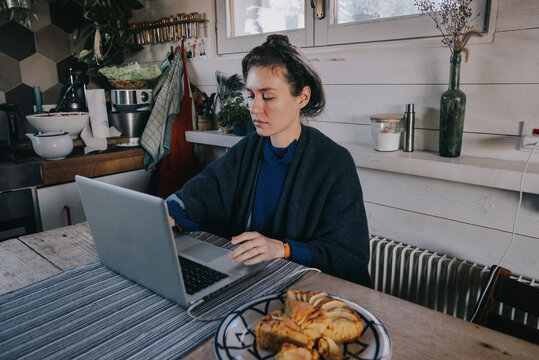 A woman working on computer in kitchen