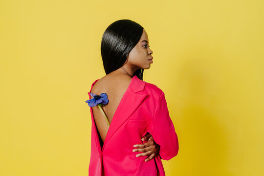 Black woman with flower on back on yellow background