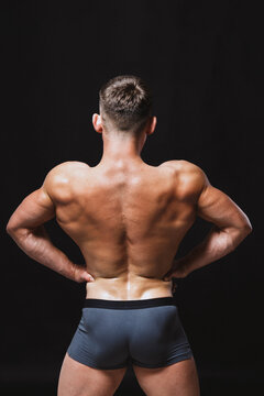 Bodybuilder showing his back while standing in spread pose