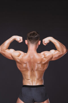 Bodybuilder posing on black isolated room