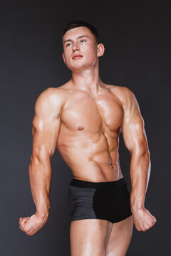 Man with athletic body posing on black background