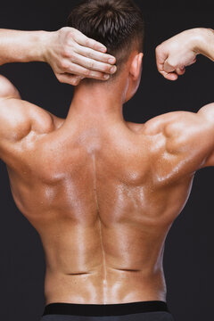 Strong male sportsman tensing muscle back