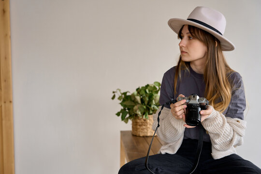 a female photographer with a camera in a hat