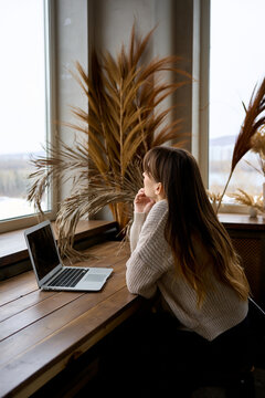 a woman works in an informal setting at home with a laptop