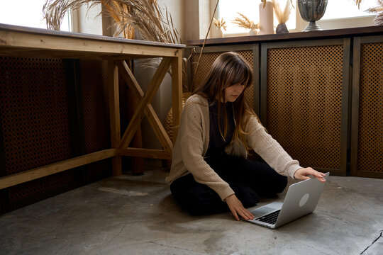 a woman works in an informal setting at home with a laptop