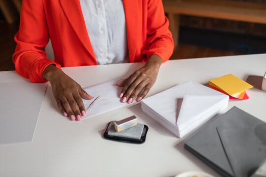Cropped businesswoman enveloping letters