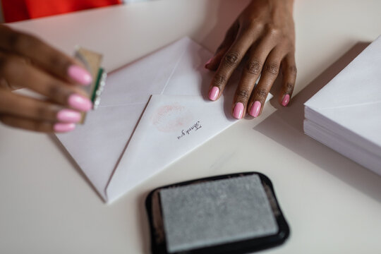 Cropped woman hands stamping thank you on an envelope
