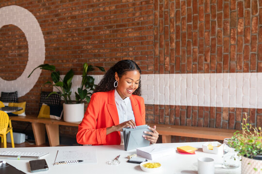 Chic manager happily preparing invitations at office