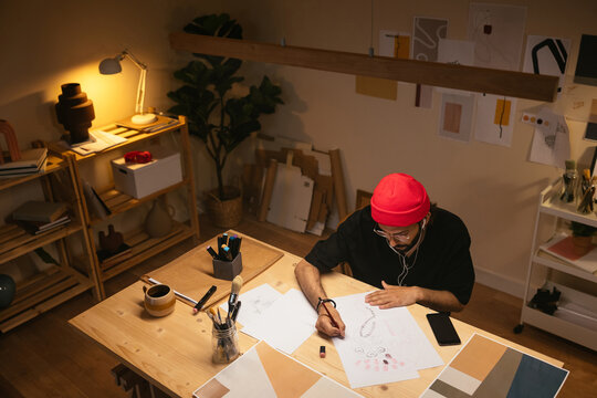 Man Creating Sketch On Illuminated Table