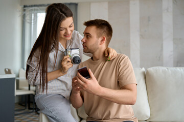 a couple taking pictures with an instant print camera