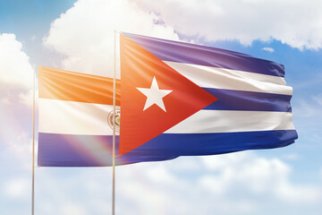 Sunny blue sky and flags of cuba and paraguay