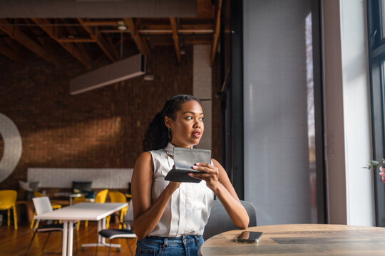 Woman taking notes in empty cowork space