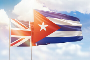 Sunny blue sky and flags of cuba and united kingdom