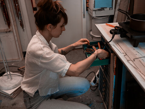 Redhead women looking for the tools in craft studio
