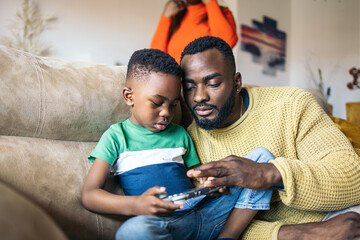 Father and son playing with a game console
