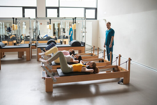 Women's team doing exercises on pilates machine