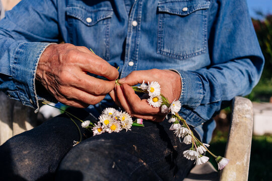 Grandfather making a daisy headband for a little girl