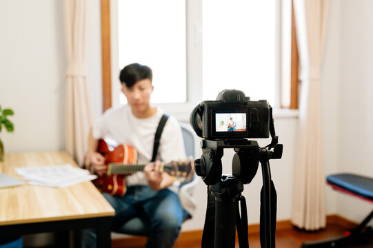 Young man with guitar live streaming his performance