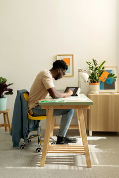 Black man designing on tablet in studio