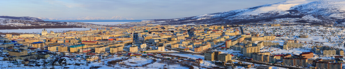 Obraz premium Panorama of Magadan city. Top view of a large northern city. Beautiful cityscape with many buildings. In the distance are mountains and a sea bay. Magadan, Siberia, Far East of Russia. Panoramic photo