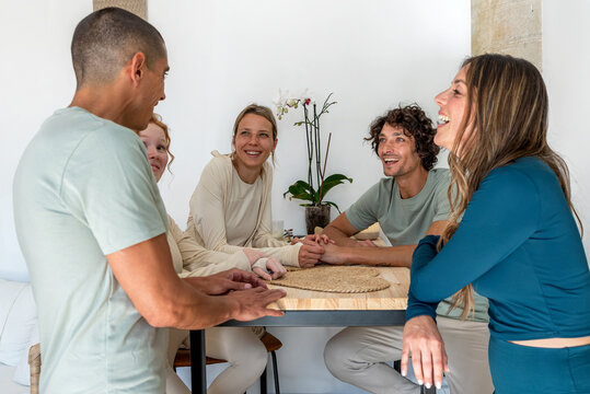 Cheerful diverse friends chatting and laughing at yoga studio