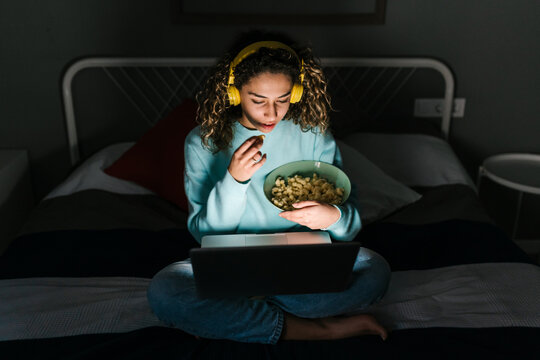 Young woman watching movie at night