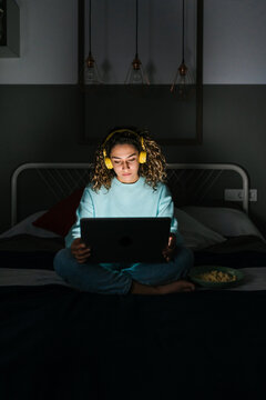 Young woman using laptop at night