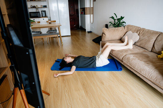 Young woman doing situps in living room