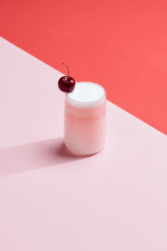 Fresh healthy berry smoothie in glass stands on pink