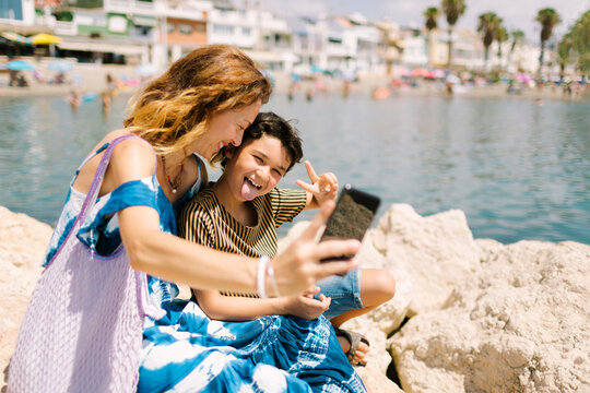 Mom smiling and son sticking out his tongue for a selfie
