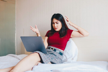 Depressed angry businesswoman looking frustrated being overworked sitting on bed