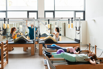 Women's team doing exercises on pilates machine