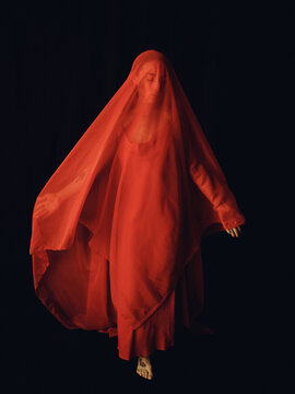 Female figure with outstretched arms covered with a red veil