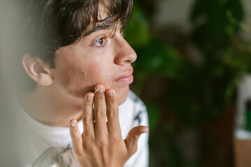 Teen boy massaging his face portrait