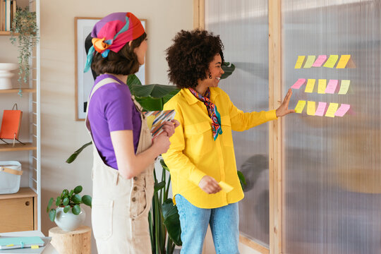 Diverse female colleagues discussing notes