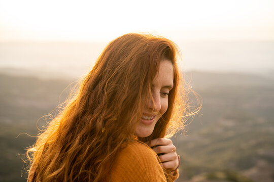Portrait of happy serene woman in nature at sunset