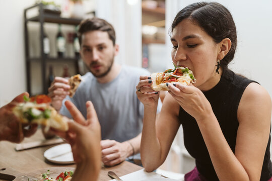 Woman bitting into a pizza slice