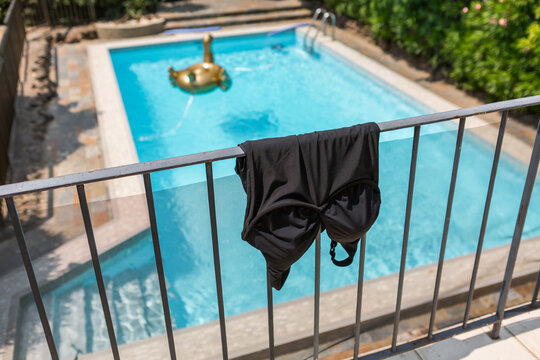 Swimsuit hanging on a pool rail