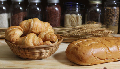 Fresh Baked Bread in Rustic Kitchen on Wooden Table With Jars of Dried Food in Background Shallow DOF