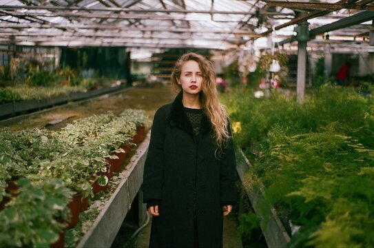 portrait of a blond woman in greenhouse