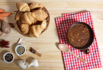 Beef Stew and Fresh Bread in Rustic Kitchen With Red and White Checkered Cloth