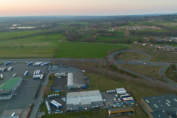 Fototapeta premium Aerial view of goods warehouses and logistics center in industrial city zone from above