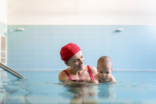 Mother teaching baby swimming pool