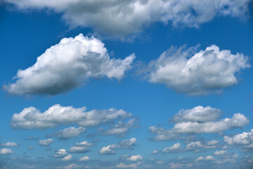 Bright landscape of white puffy cumulus clouds on blue clear sky